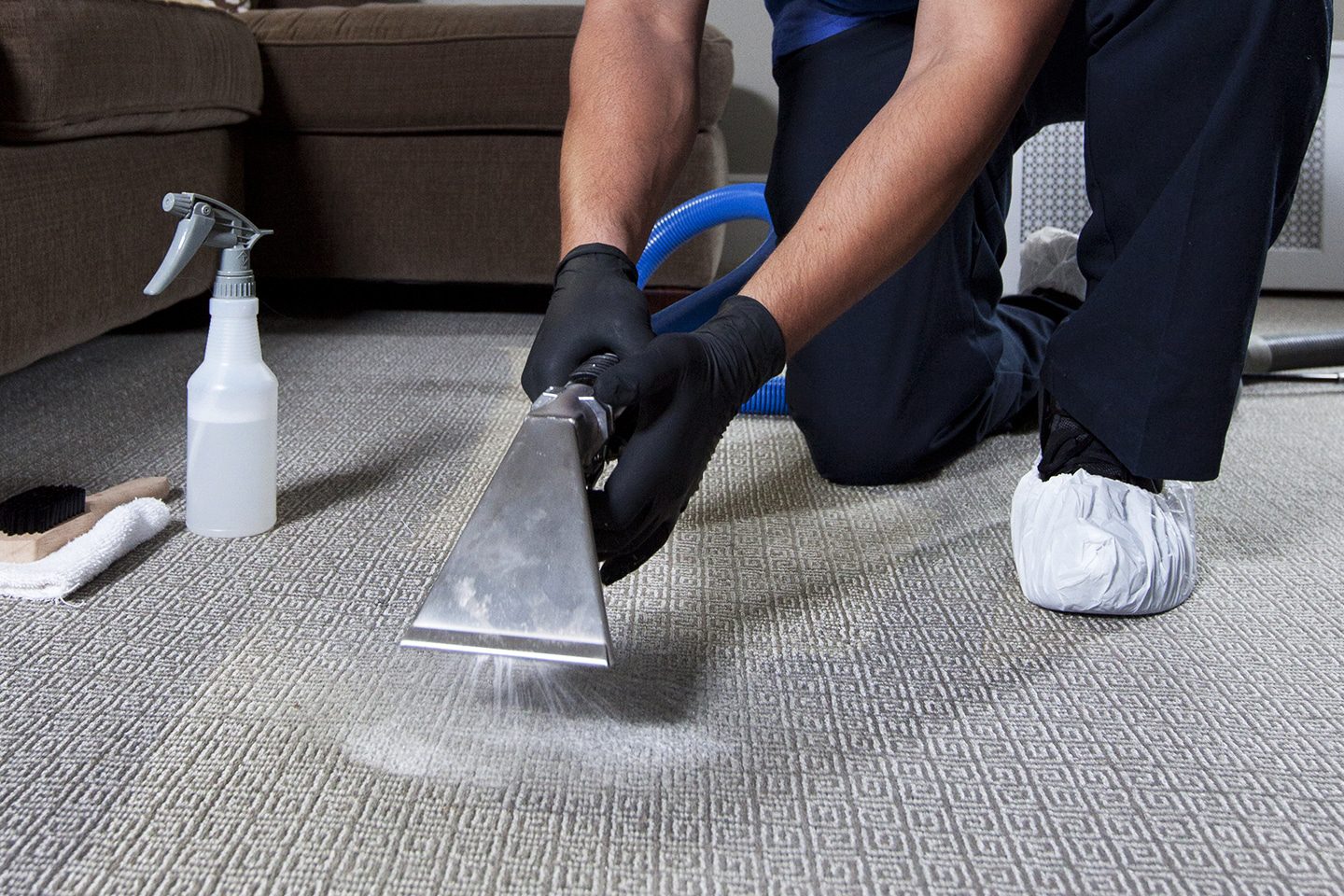 a person cleaning carpet with vacuum cleaner