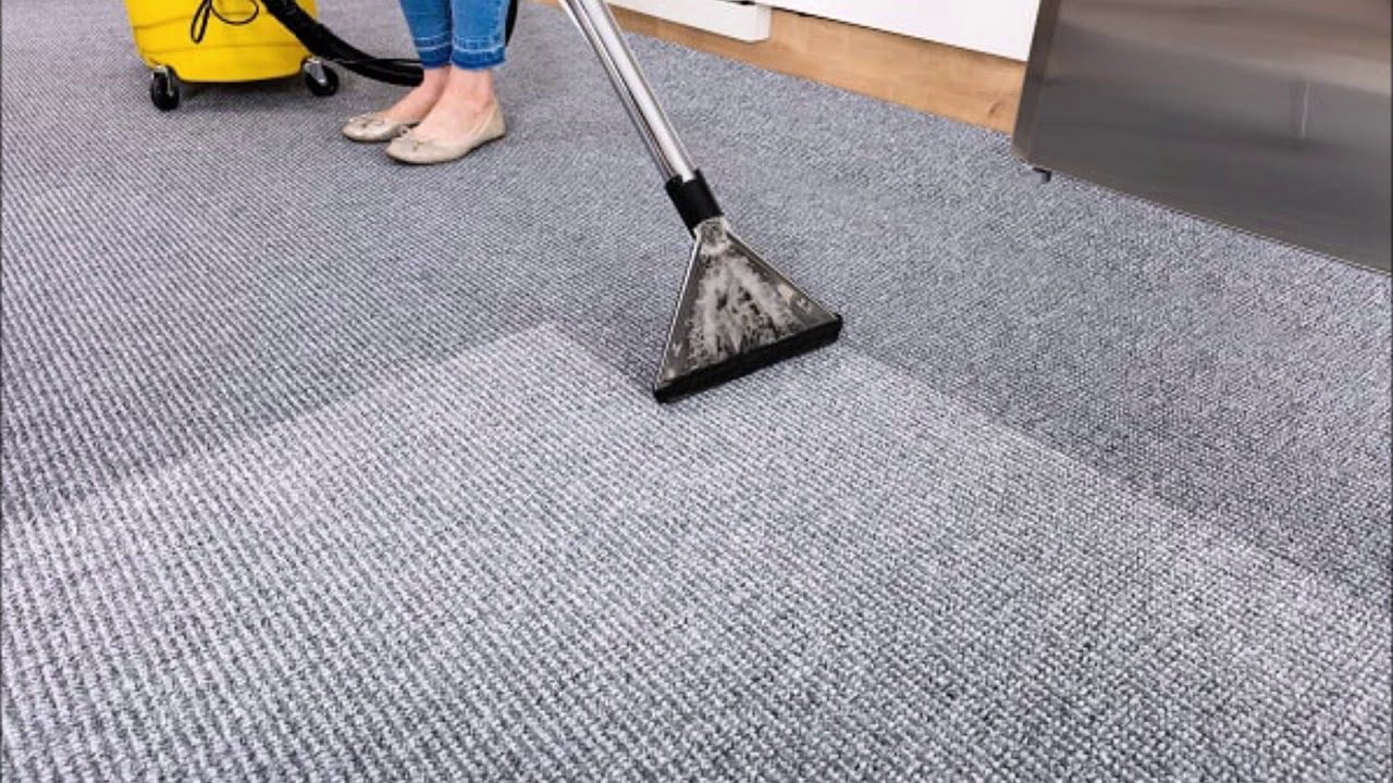 a person cleaning carpet with vacuum cleaner