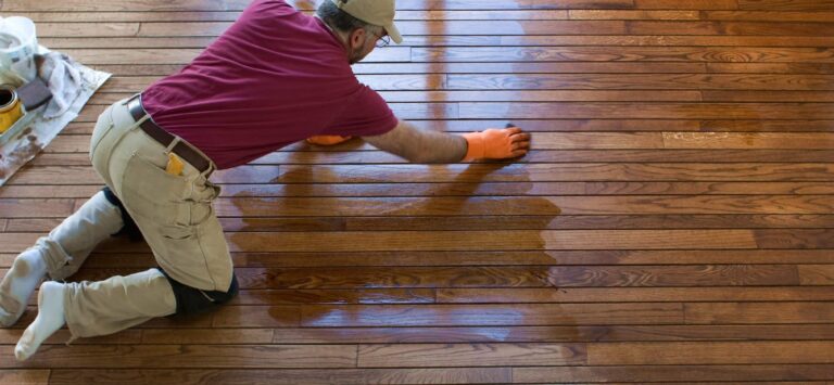 a person on his knees polishing hardwood floor.